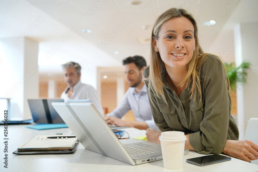 Female startup team member smiling at camera in office Female startup team member smiling at camera in office