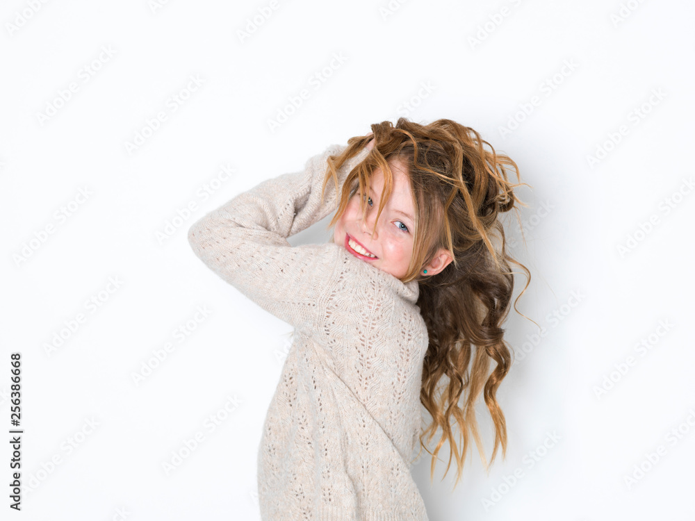 Naklejka premium pretty blonde girl with curly hair posing against a white background and is happy