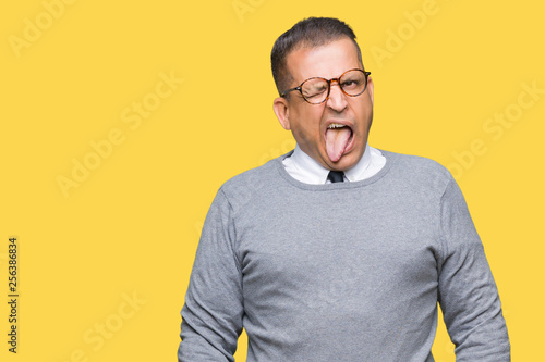 Middle age bussines arab man wearing glasses over isolated background sticking tongue out happy with funny expression. Emotion concept. © Krakenimages.com