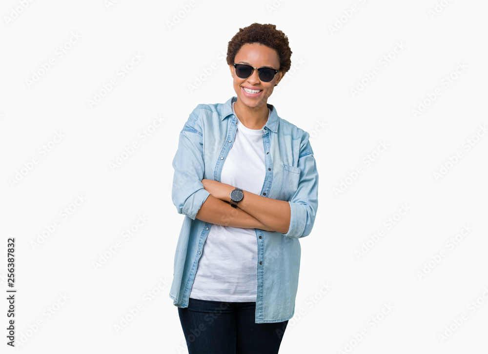Beautiful young african american woman wearing sunglasses over isolated background happy face smiling with crossed arms looking at the camera. Positive person. Beautiful young african american woman wearing sunglasses over isolated background happy face smiling with crossed arms looking at the camera. Positive person.
