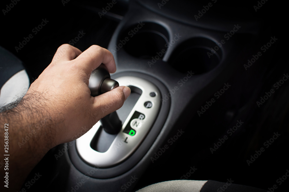 Hand of driver put a gear stick into D position, (Drive) Symbol in auto transmission car.