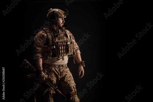 Special forces United States soldier or private military contractor holding rifle. Image on a black background. war, army and people concept