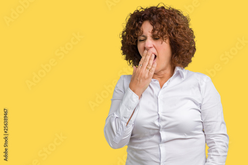 Beautiful middle ager senior businees woman over isolated background bored yawning tired covering mouth with hand. Restless and sleepiness.