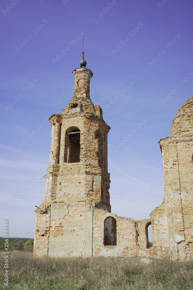 Old destroyed and abandoned church against the blue sky, in the middle of the field Old destroyed and abandoned church against the blue sky, in the middle of the field