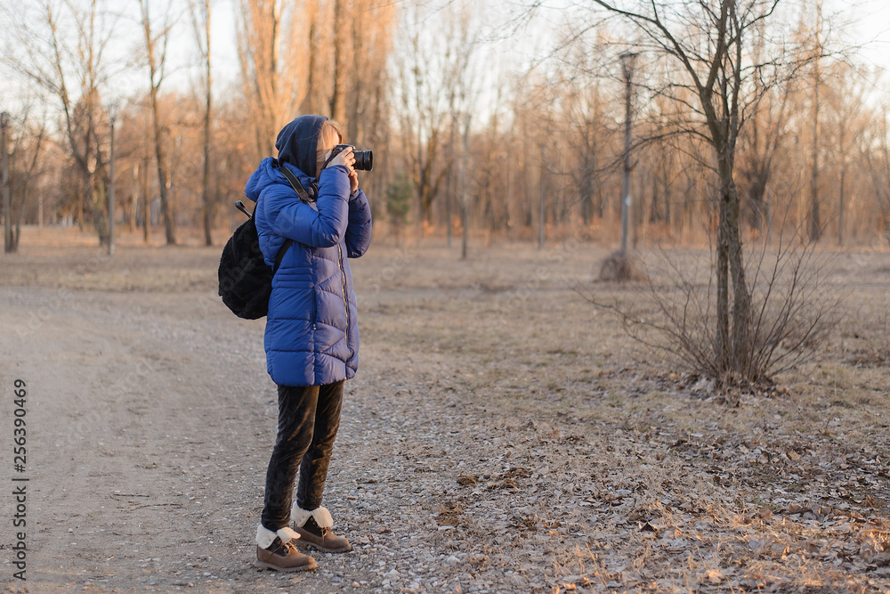 Fototapeta premium A woman photographer holds a camera in her hands. The concept of a woman photojournalist.