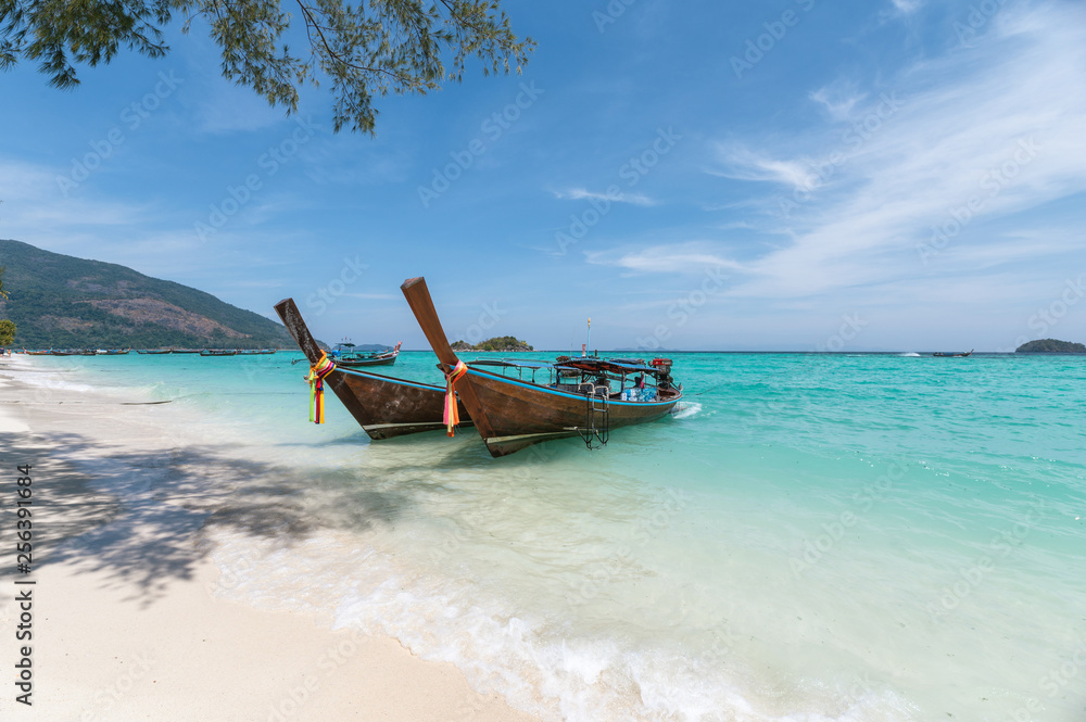 Wooden long-tail boats on crystal tropical sea Wooden long-tail boats on crystal tropical sea