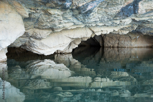 Entrance to pale rock Sadan Cave, near Hpa An, Myanmar and its reflection in river photo