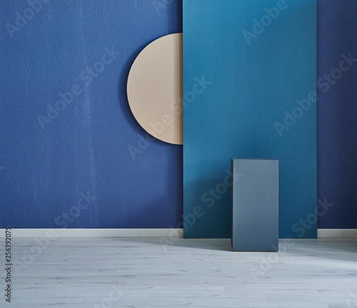 Dark blue room  brown wooden round object on the wall and blue table.