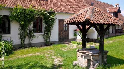 A traditional rural house with garden and well in the village of Valea Zălanului, Covasna - Romania photo