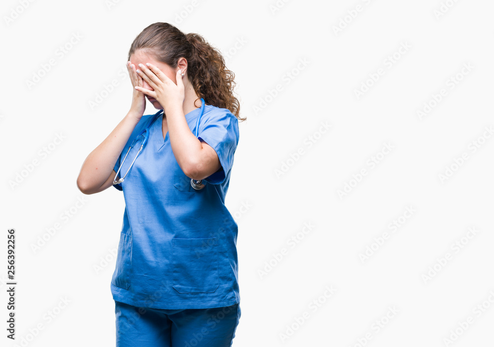 Young brunette doctor girl wearing nurse or surgeon uniform over isolated background with sad expression covering face with hands while crying. Depression concept. Young brunette doctor girl wearing nurse or surgeon uniform over isolated background with sad expression covering face with hands while crying. Depression concept.