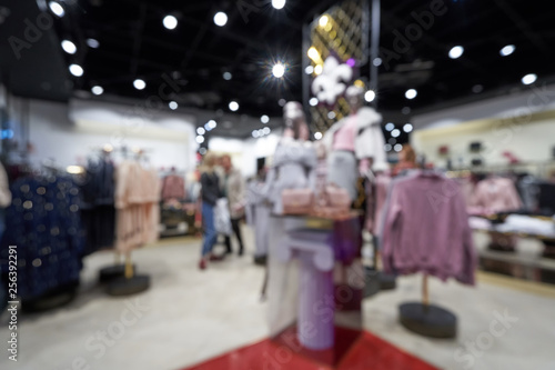 Beautiful blurred background of a women's clothing store in a mall. Defocused. Shopping mall or department store with blurred background and bokeh light.