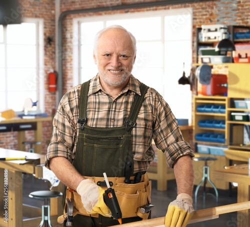 Senior happy handyman working at DIY workshop