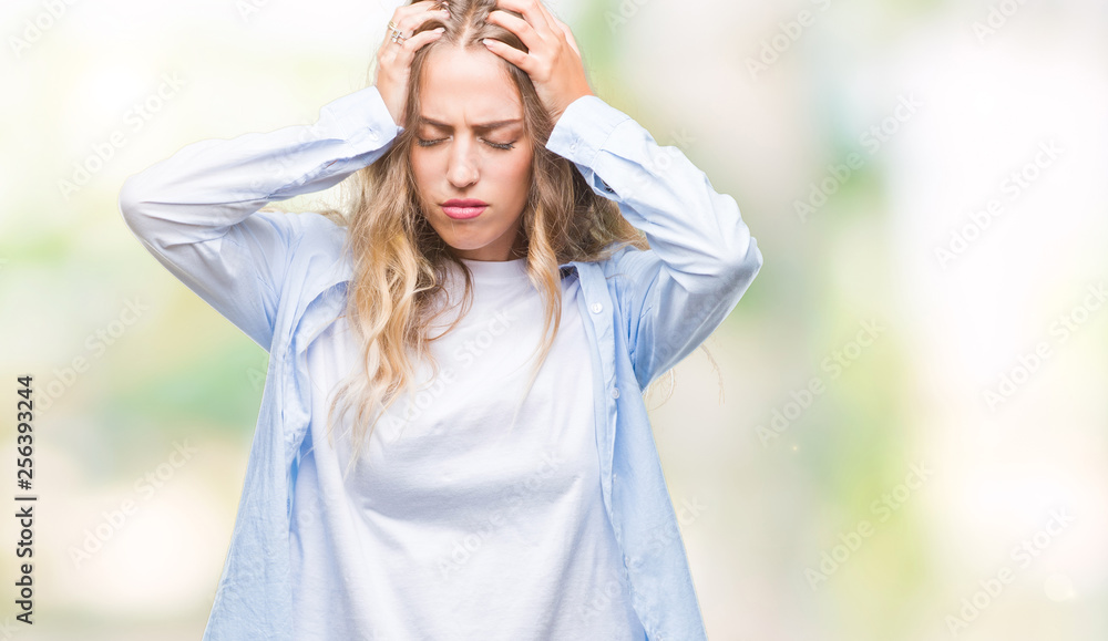 Beautiful young blonde woman over isolated background suffering from headache desperate and stressed because pain and migraine. Hands on head. Beautiful young blonde woman over isolated background suffering from headache desperate and stressed because pain and migraine. Hands on head.
