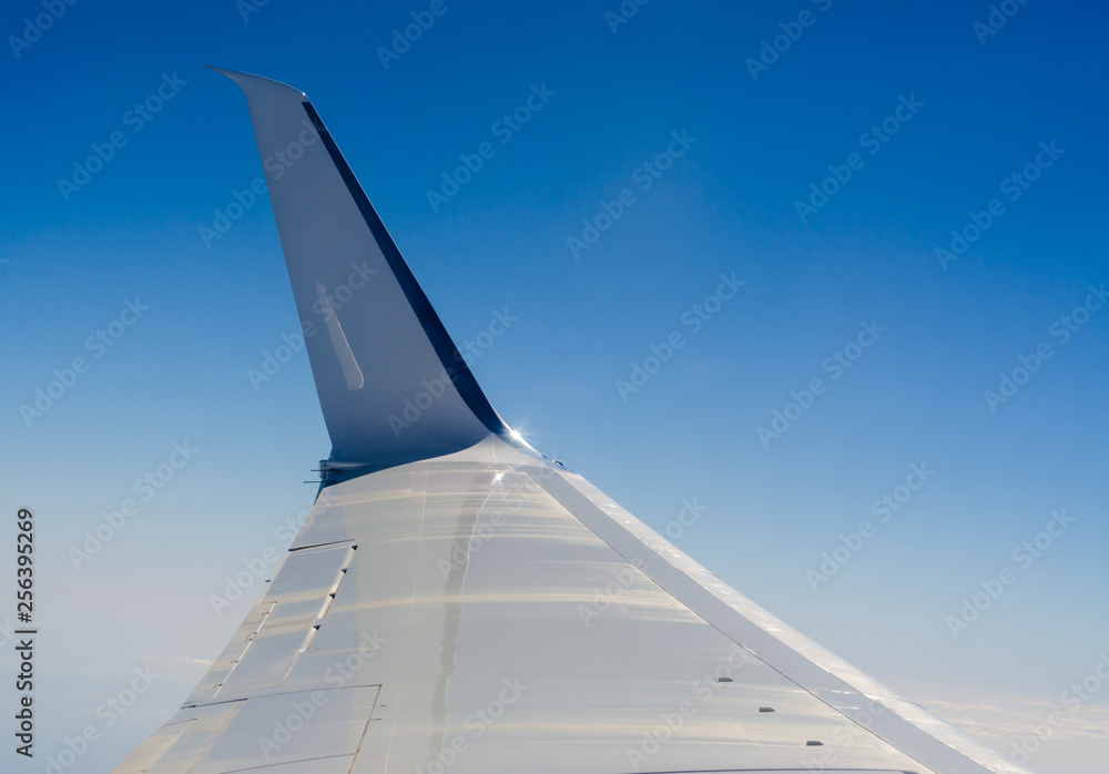 wing of the flying plane on a background of blue sky