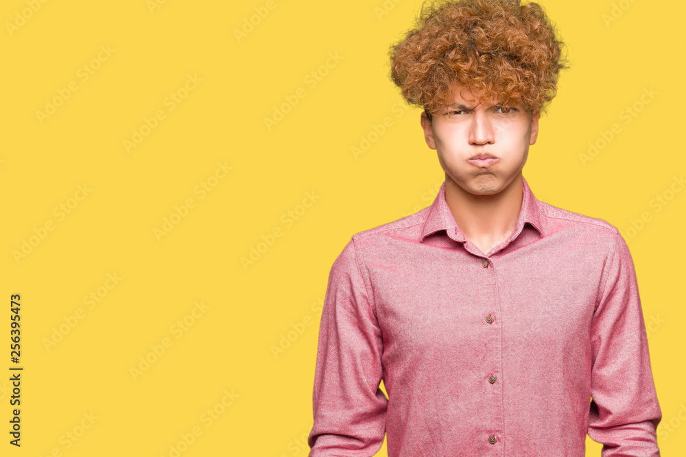 Young handsome business man with afro hair puffing cheeks with funny face. Mouth inflated with air, crazy expression. Young handsome business man with afro hair puffing cheeks with funny face. Mouth inflated with air, crazy expression.