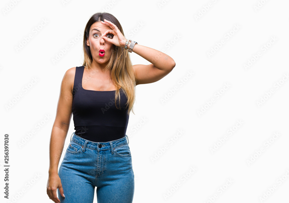 Young beautiful woman over isolated background doing ok gesture shocked with surprised face, eye looking through fingers. Unbelieving expression. Young beautiful woman over isolated background doing ok gesture shocked with surprised face, eye looking through fingers. Unbelieving expression.