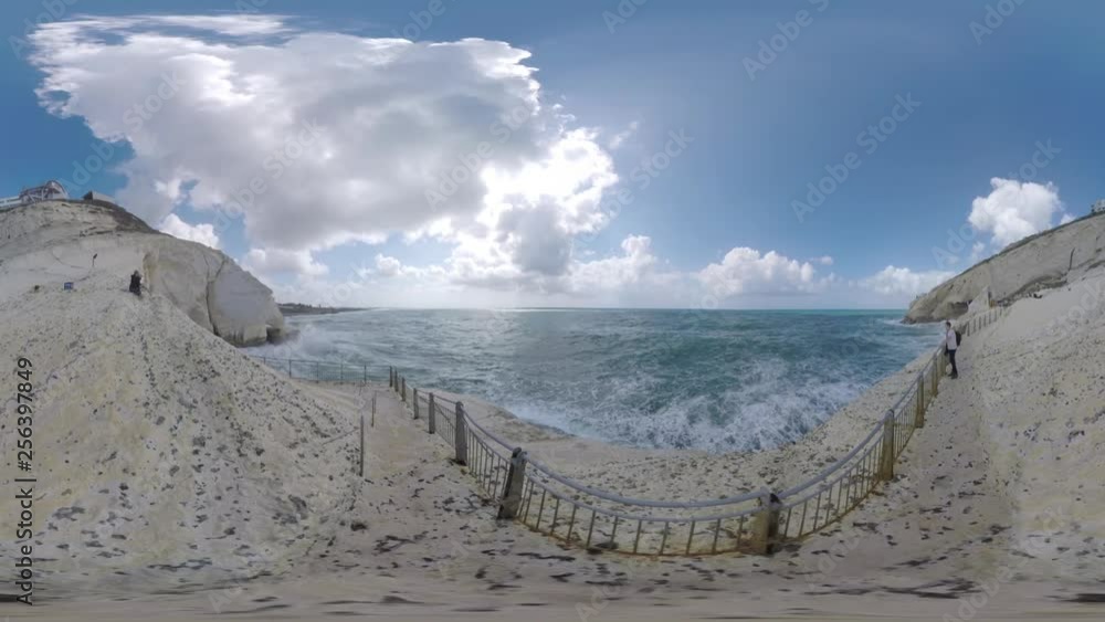 ROSH HANIKRA, ISRAEL - MARCH 12, 2017: 360 VR video. Scene with Rosh HaNikra. Sea and white chalk cliff with cable way and several tourists enjoying waterscape ROSH HANIKRA, ISRAEL - MARCH 12, 2017: 360 VR video. Scene with Rosh HaNikra. Sea and white chalk cliff with cable way and several tourists enjoying waterscape