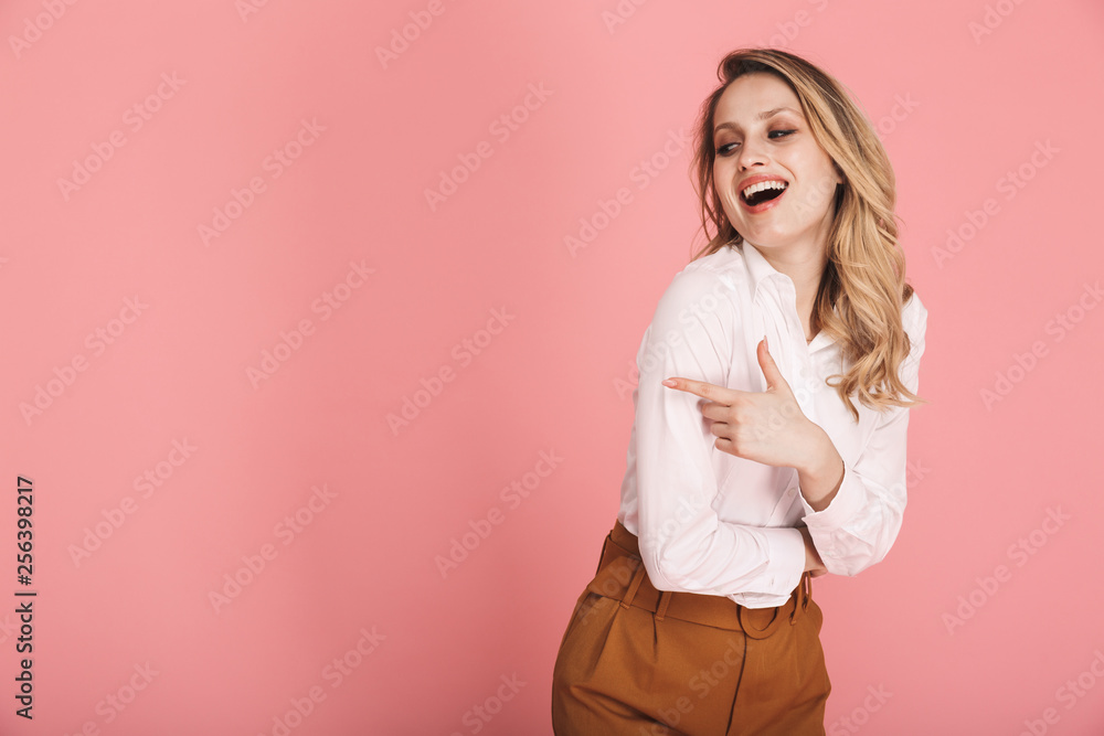 Portrait of glamour blond woman 30s in stylish outfit smiling and pointing finger at copyspace Portrait of glamour blond woman 30s in stylish outfit smiling and pointing finger at copyspace