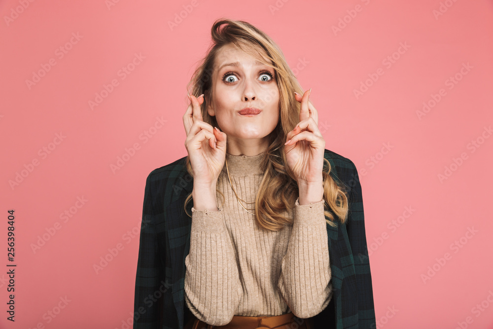 Portrait of trendy blond woman 30s in stylish outfit keeping fingers crossed and wishing for fortune or luck Portrait of trendy blond woman 30s in stylish outfit keeping fingers crossed and wishing for fortune or luck