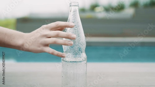 Hand streift über Wasserflasche