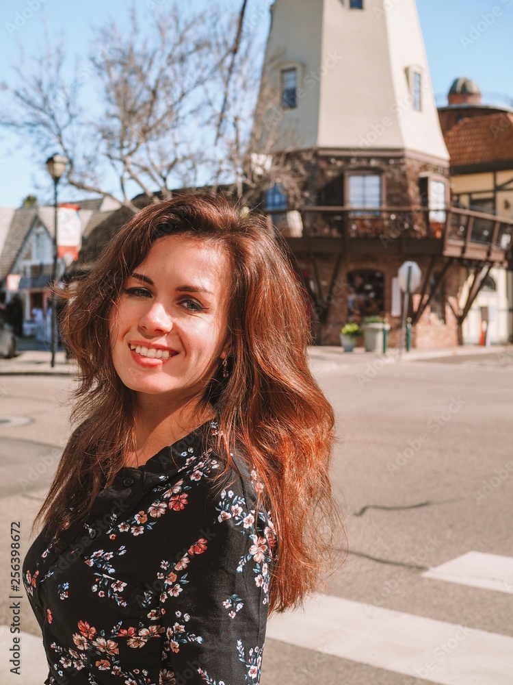 Portrait of a brunette girl with long hair and a black dress on the streets of Sunny Solvang, similar to Denmark Portrait of a brunette girl with long hair and a black dress on the streets of Sunny Solvang, similar to Denmark