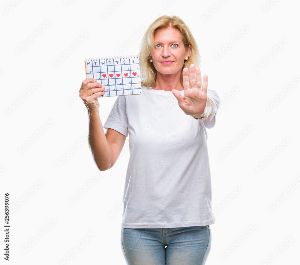 Middle age blonde woman holding menstruation calendar ver isolated background with open hand doing stop sign with serious and confident expression, defense gesture Middle age blonde woman holding menstruation calendar ver isolated background with open hand doing stop sign with serious and confident expression, defense gesture