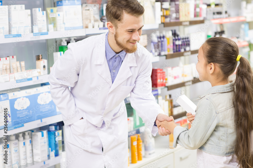 Pharmacist helping little girl at the drugstore