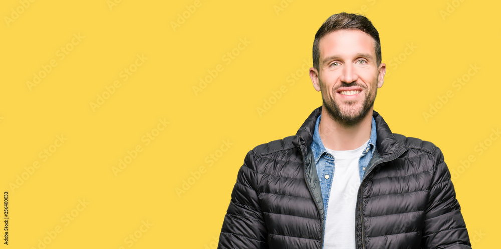 Handsome man wearing winter coat Hands together and fingers crossed smiling relaxed and cheerful. Success and optimistic Handsome man wearing winter coat Hands together and fingers crossed smiling relaxed and cheerful. Success and optimistic