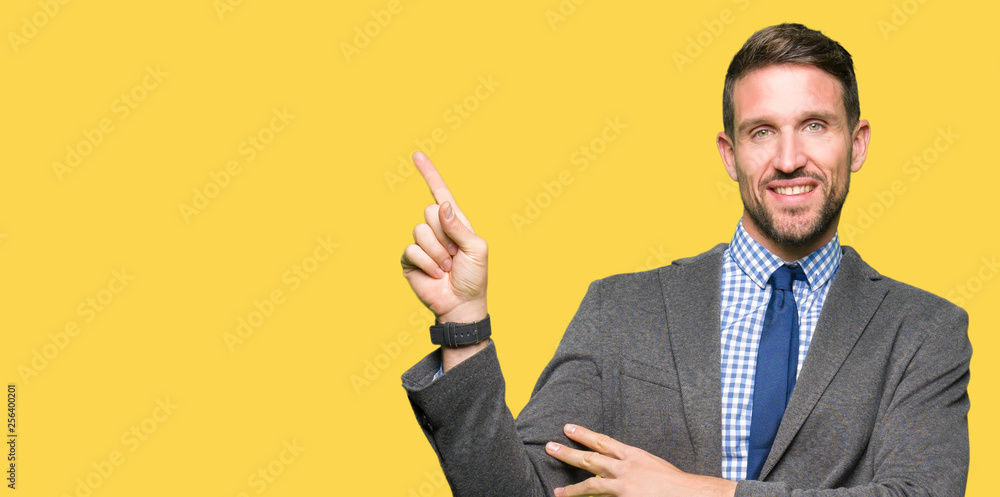 Handsome business man wearing suit and tie with a big smile on face, pointing with hand and finger to the side looking at the camera. Handsome business man wearing suit and tie with a big smile on face, pointing with hand and finger to the side looking at the camera.