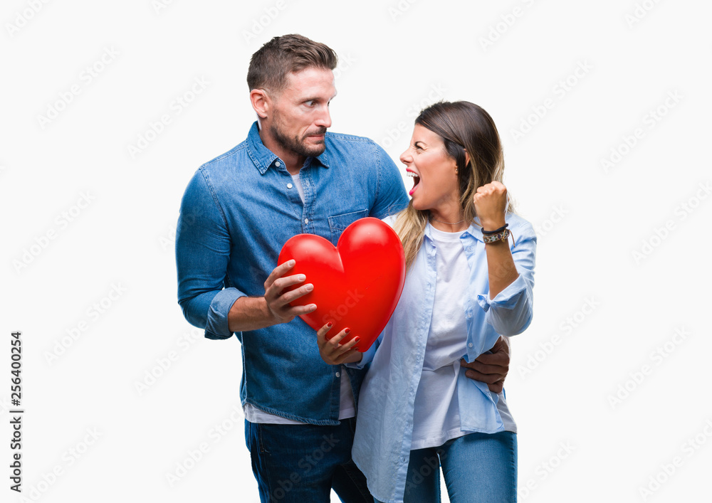 Young couple in love holding red heart over isolated background annoyed and frustrated shouting with anger, crazy and yelling with raised hand, anger concept Young couple in love holding red heart over isolated background annoyed and frustrated shouting with anger, crazy and yelling with raised hand, anger concept