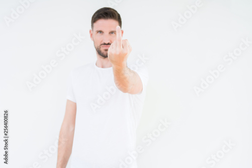 Young handsome man wearing casual white t-shirt over isolated background Showing middle finger, impolite and rude fuck off expression