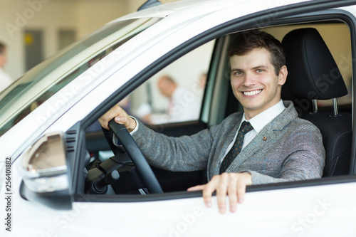 Attrative young businessman in a car