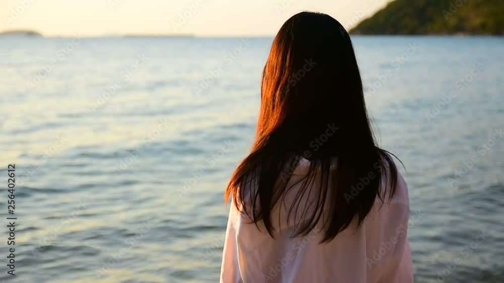 Women standing on beach at sea sunset background on evening golden hour.Travel summer holiday sea beach in Thailand Women standing on beach at sea sunset background on evening golden hour.Travel summer holiday sea beach in Thailand