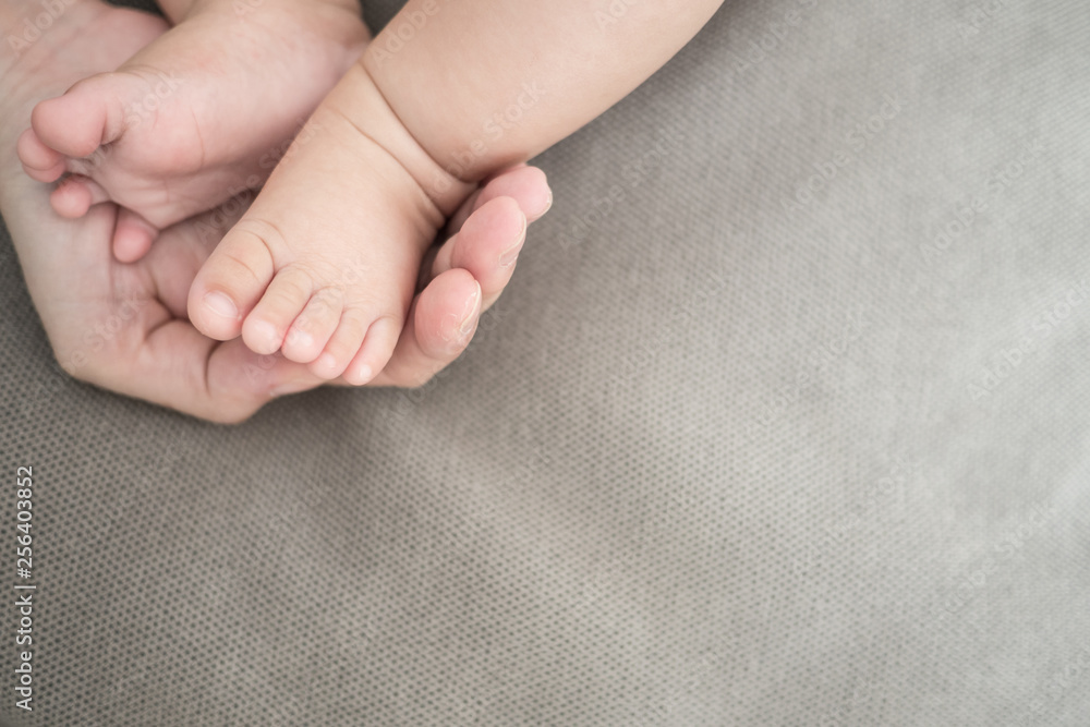 New born baby foot on grey fabric background New born baby foot on grey fabric background