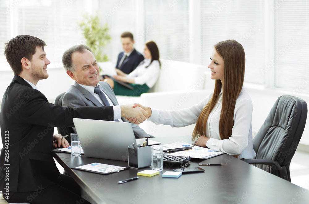 business woman shaking hands with an adult business partner. business woman shaking hands with an adult business partner.
