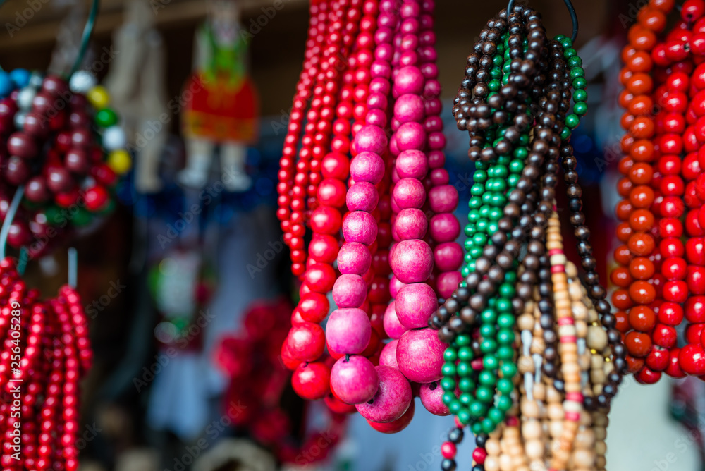 Colorful small and large beads on a string hang at the city fair.