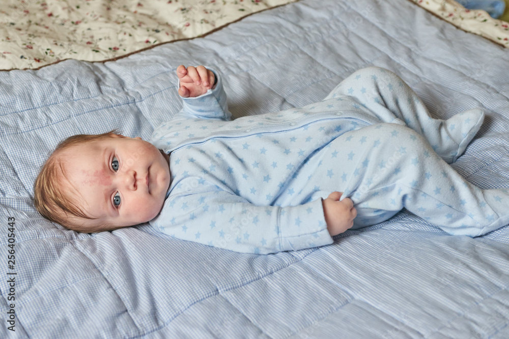 Beautiful baby with blue eyes lying on the bed Beautiful baby with blue eyes lying on the bed