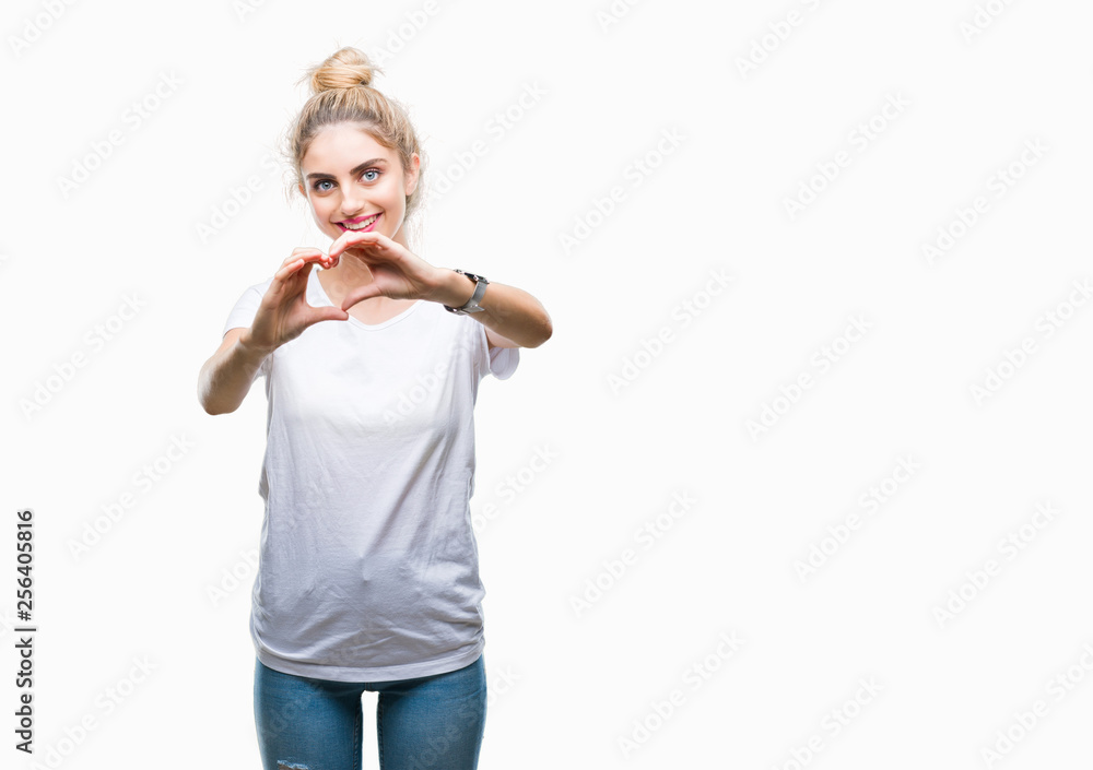 Young beautiful blonde woman wearing white t-shirt over isolated background smiling in love showing heart symbol and shape with hands. Romantic concept. Young beautiful blonde woman wearing white t-shirt over isolated background smiling in love showing heart symbol and shape with hands. Romantic concept.