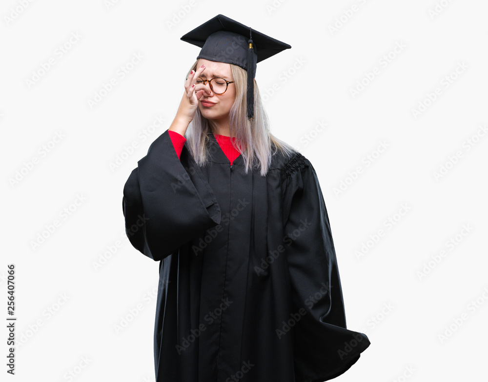 Young blonde woman wearing graduate uniform over isolated background smelling something stinky and disgusting, intolerable smell, holding breath with fingers on nose. Bad smells concept. Young blonde woman wearing graduate uniform over isolated background smelling something stinky and disgusting, intolerable smell, holding breath with fingers on nose. Bad smells concept.