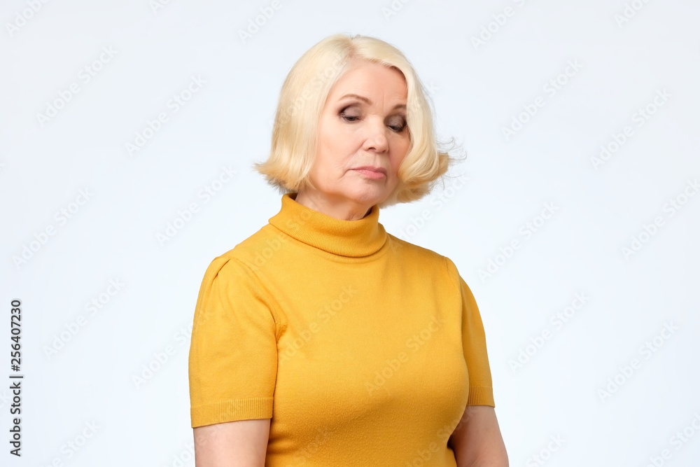 Sad senior blonde woman in yellow clothes Sad senior blonde woman in yellow clothes