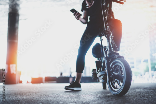 Electric urban transportation.Young man ready to ride his electric scooter bike in the center of a city. Innovative transport