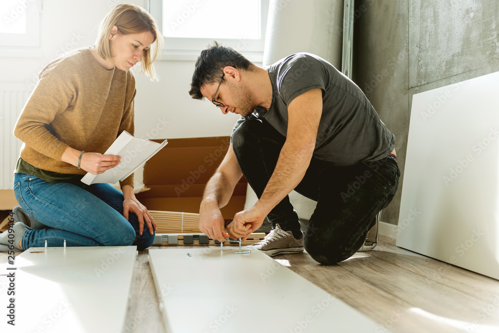 Fototapeta premium Couple assembling furniture in their new house 