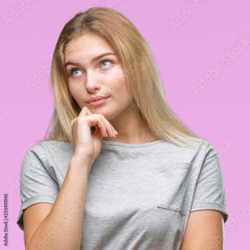Young caucasian woman over isolated background with hand on chin thinking about question, pensive expression. Smiling with thoughtful face. Doubt concept.