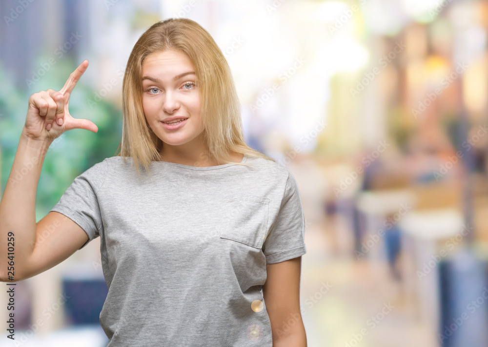 Young caucasian woman over isolated background smiling and confident gesturing with hand doing size sign with fingers while looking and the camera. Measure concept. Young caucasian woman over isolated background smiling and confident gesturing with hand doing size sign with fingers while looking and the camera. Measure concept.