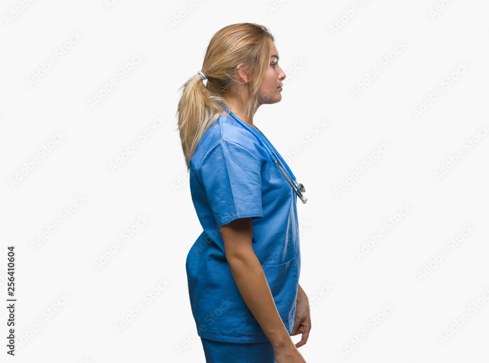 Young caucasian doctor woman wearing surgeon uniform over isolated background looking to side, relax profile pose with natural face with confident smile. Young caucasian doctor woman wearing surgeon uniform over isolated background looking to side, relax profile pose with natural face with confident smile.