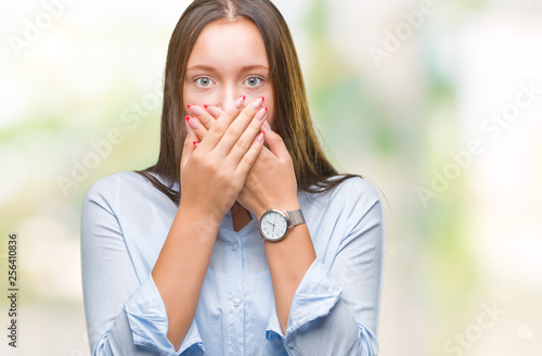 Young caucasian beautiful woman over isolated background shocked covering mouth with hands for mistake. Secret concept.