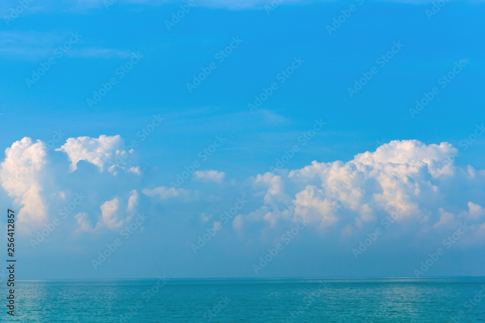 Obraz premium Beautiful morning white and pink clouds on a blue sky over the sea.Copy space in the sky above the clouds. Sunrise and sunset .Concept of decoration, travel, vacation,relaxation.