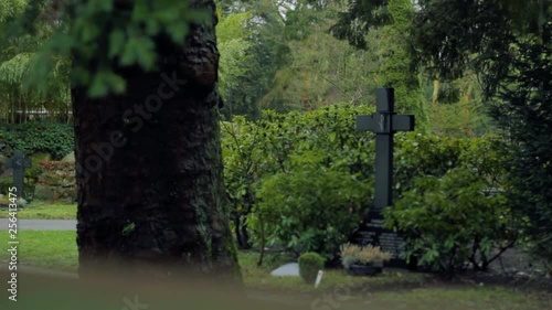 Cross and Tombstone in Green Graveyard