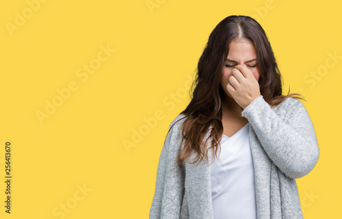 Beautiful plus size young woman wearing winter jacket over isolated background tired rubbing nose and eyes feeling fatigue and headache. Stress and frustration concept. © Krakenimages.com