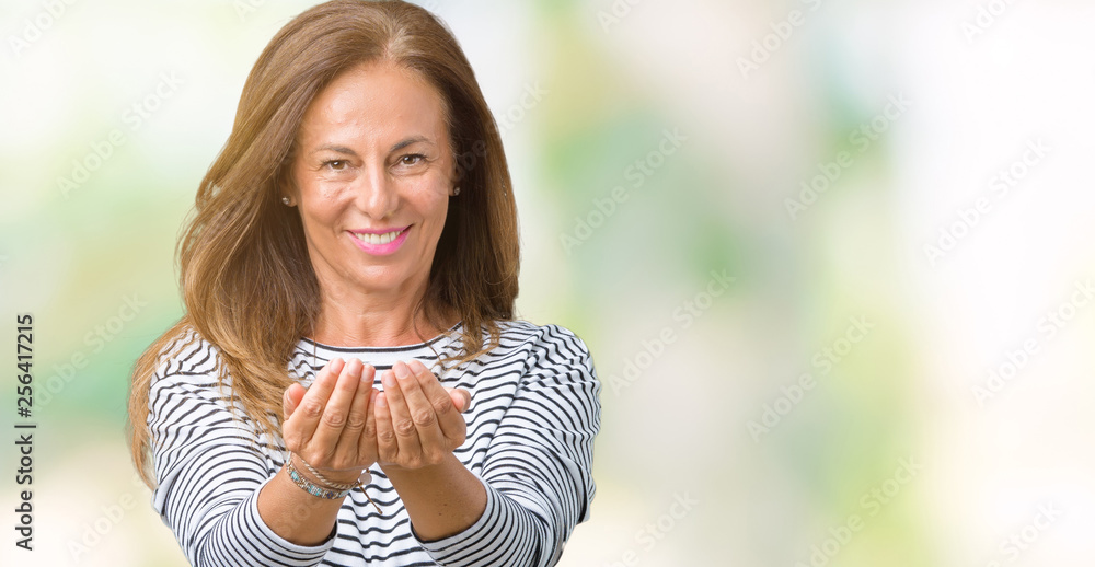 Beautiful middle age woman wearing stripes sweater over isolated background Smiling with hands palms together receiving or giving gesture. Hold and protection Beautiful middle age woman wearing stripes sweater over isolated background Smiling with hands palms together receiving or giving gesture. Hold and protection